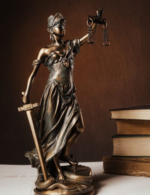 a-estatueta-de-themis-fica-em-uma-mesa-de-madeira-branca-ao-lado-de-uma-pilha-de-livros-antigos-conceito-de-negocio-de-advogado-de-direito-de-escalas-imagem_132310-2630